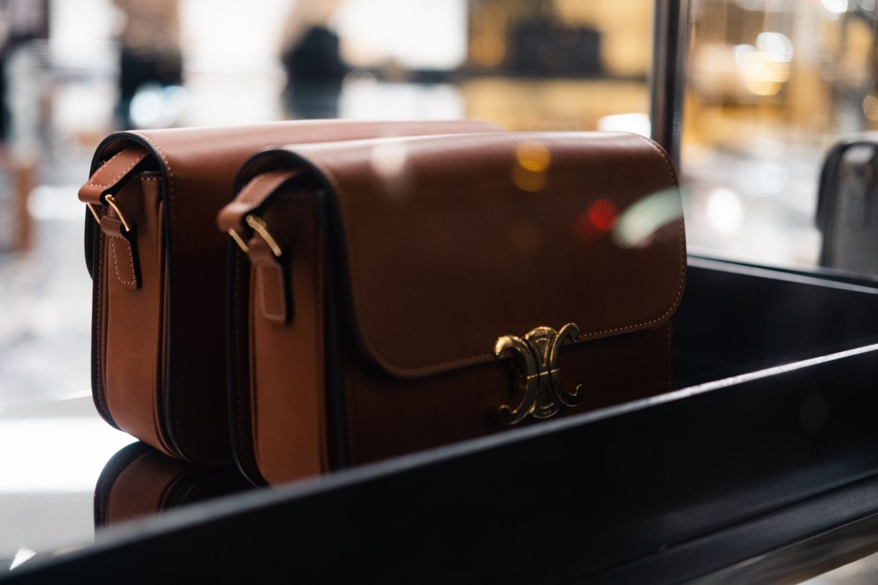 services-01 Stylish brown leather handbags showcased indoors with soft focus lights.