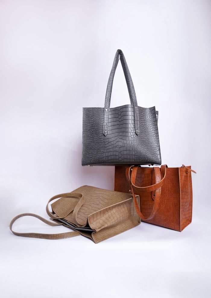 journey-01 Stylish leather handbags in a studio setup showcasing modern fashion.